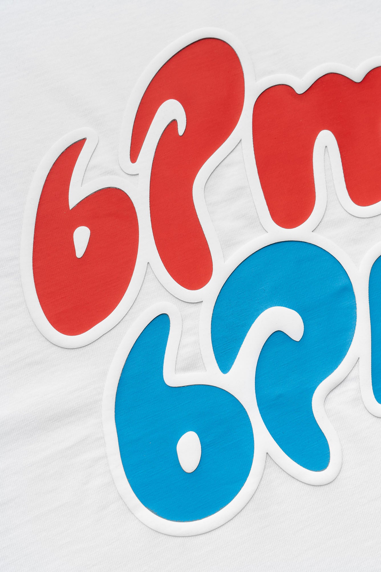 The ICE CREAM T-SHIRT WHITE by 6PM features red and blue bubble numbers and letters on white fabric, with "6PM" in red above "6AM" in blue, both outlined in white.