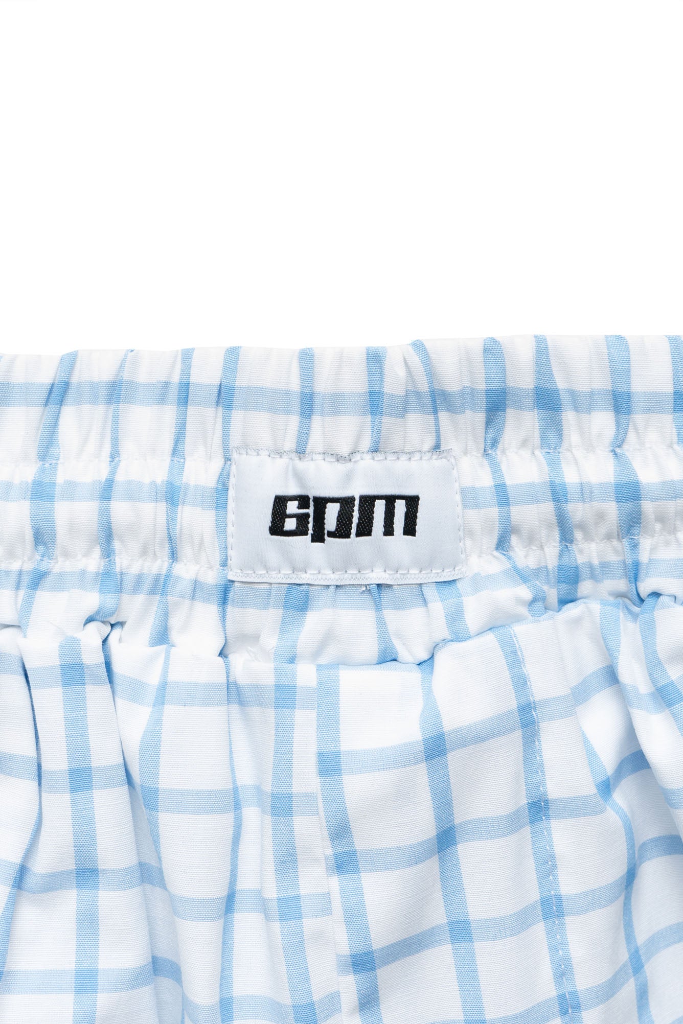 Close-up of the waistband on BOXERSHORTS SHORTS WHITE/BLUE by 6PM, featuring a white label with black 6PM branding.