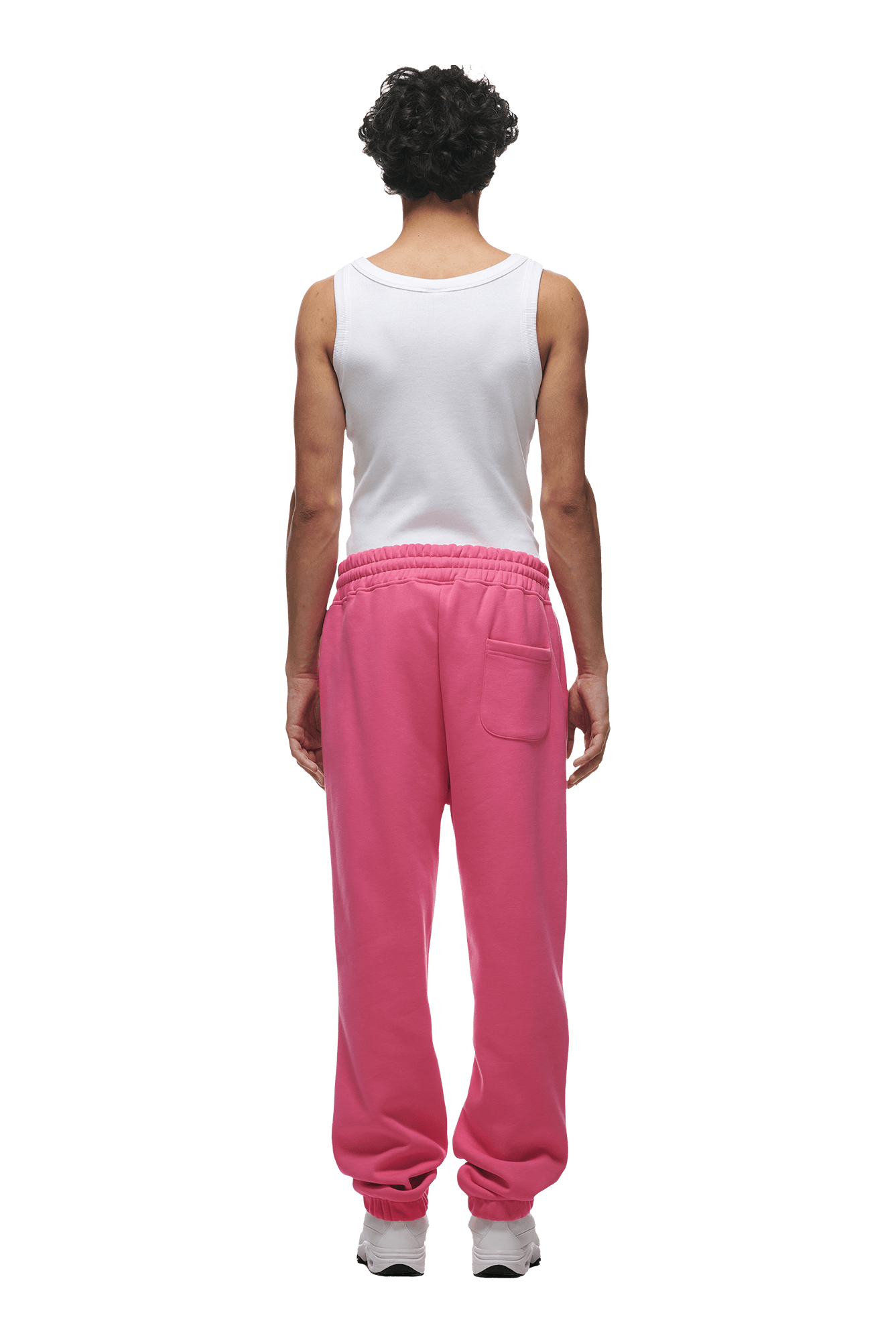 A person with curly dark hair, seen from behind, wears a white tank top and the 6PM CUFF JOGGER HOT PINK sweatpants with a pocket and cuffed leg, paired with white sneakers, standing against a transparent background.