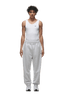 A person faces forward wearing a fitted white tank top, 6PM CUFF JOGGER LIGHT GREY sweatpants with cuffed legs, and white sneakers. The background is transparent.