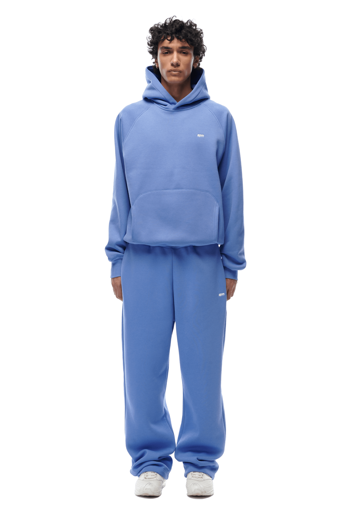 A person stands facing forward in a matching 6PM HOODIE PERSIAN BLUE raglan-sleeve hoodie and sweatpants set with white sneakers. The hoodie has a front kangaroo pocket, ideal for daily wear. Background is transparent.