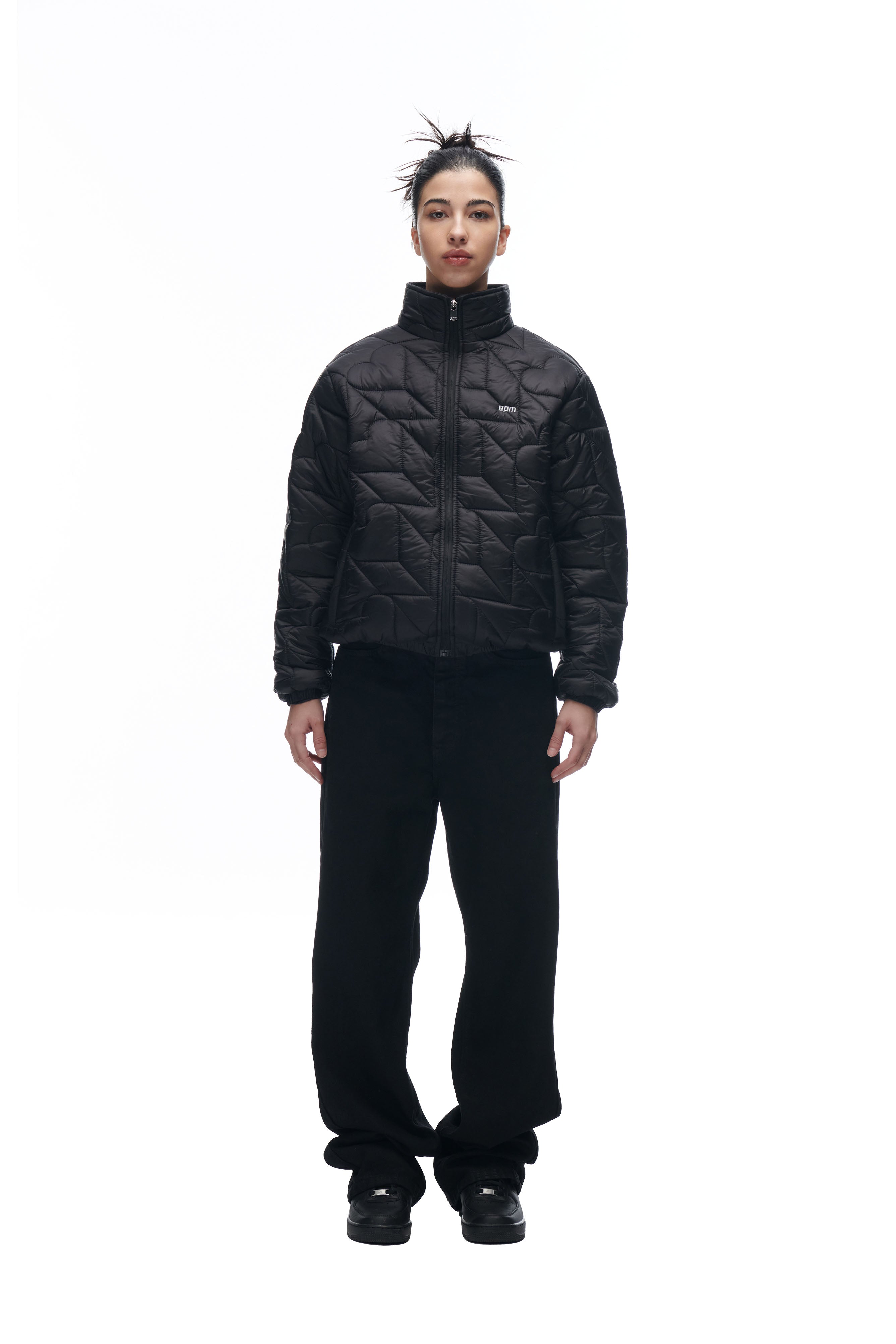 A person with dark spiked hair wears the 6PM HEART SPRING JACKET, loose black pants, and black shoes, standing against a plain white background.