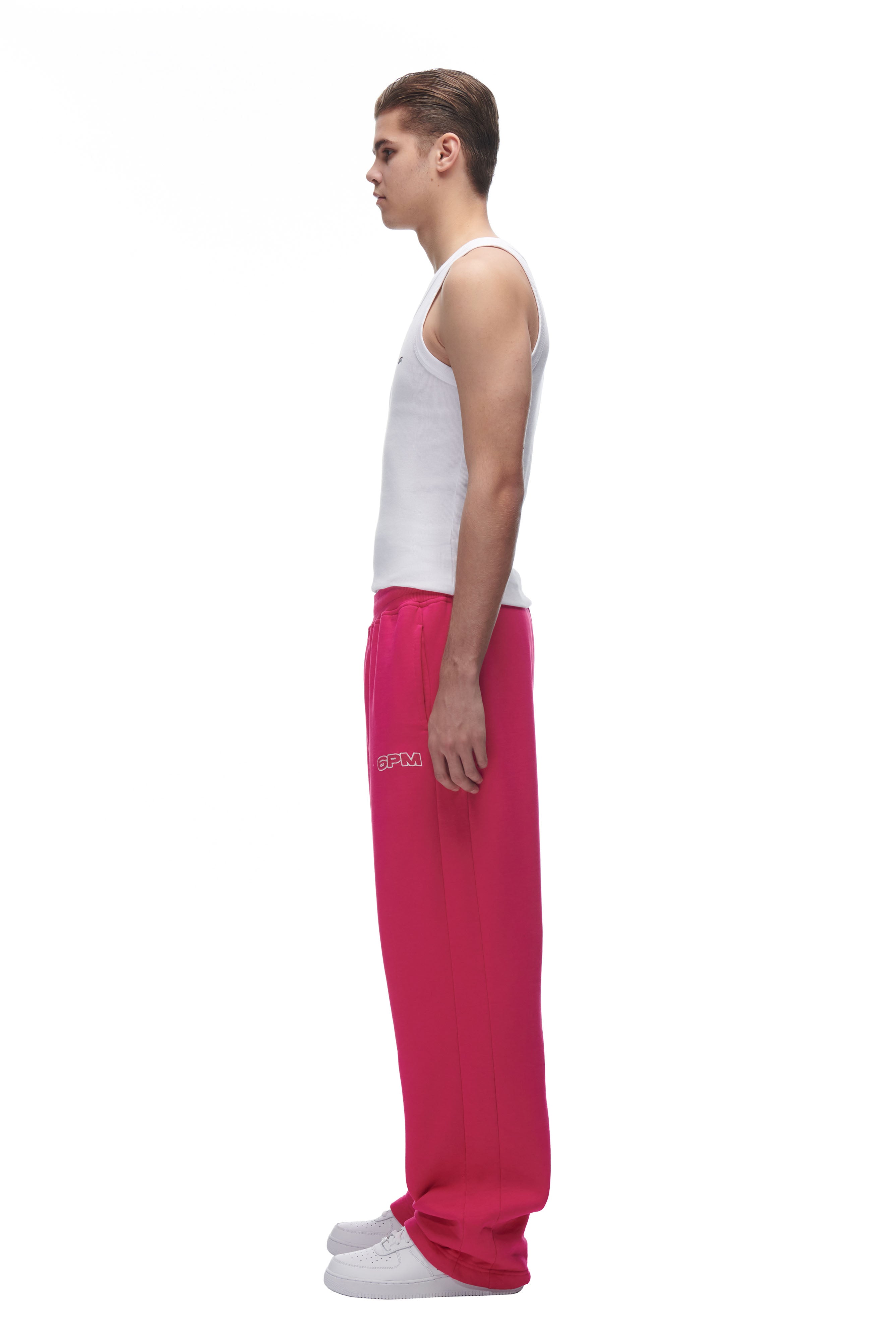 A man is wearing 6PM's LH SWEATPANT PINK and a white tank top.