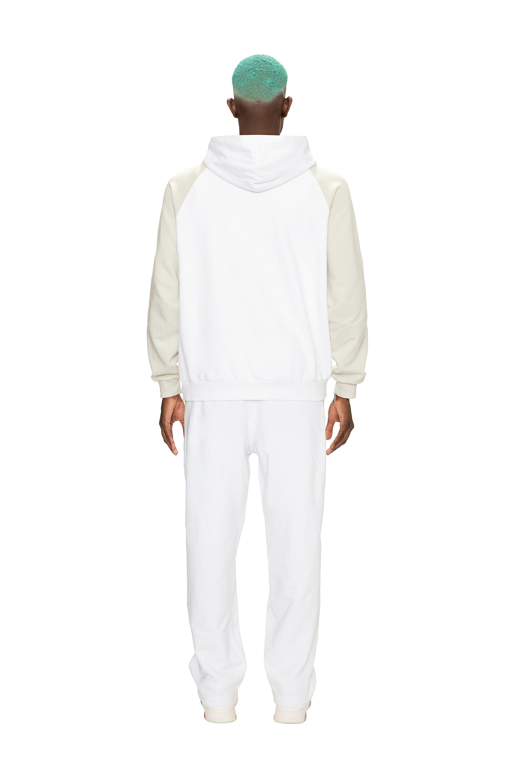 A person with short teal hair stands facing away, wearing the 6PM 2-TONE JOGGER WHITE set (white hoodie with off-white sleeves and matching white pants) against a plain white background.