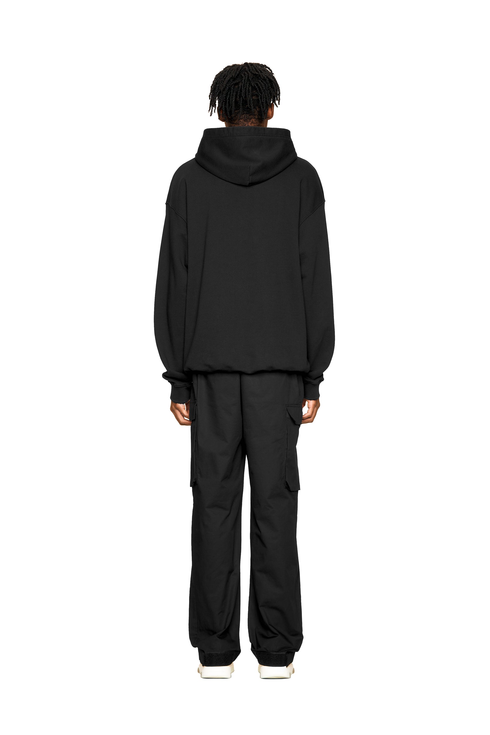 A person with short dreadlocks, seen from behind, wears the 6PM ONLY WEAR AFTER 6PM HOODIE 2.0 and black cargo pants, standing against a plain white background.