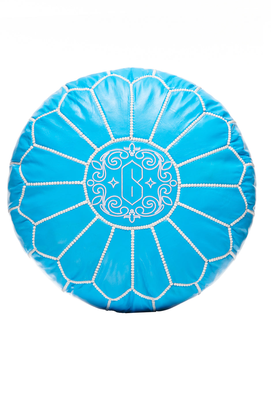 The 6PM MEDINA SEAT CUSHION BLUE features a round turquoise design with white floral stitching and an ornate “B” monogram in the center, displayed on a white background.