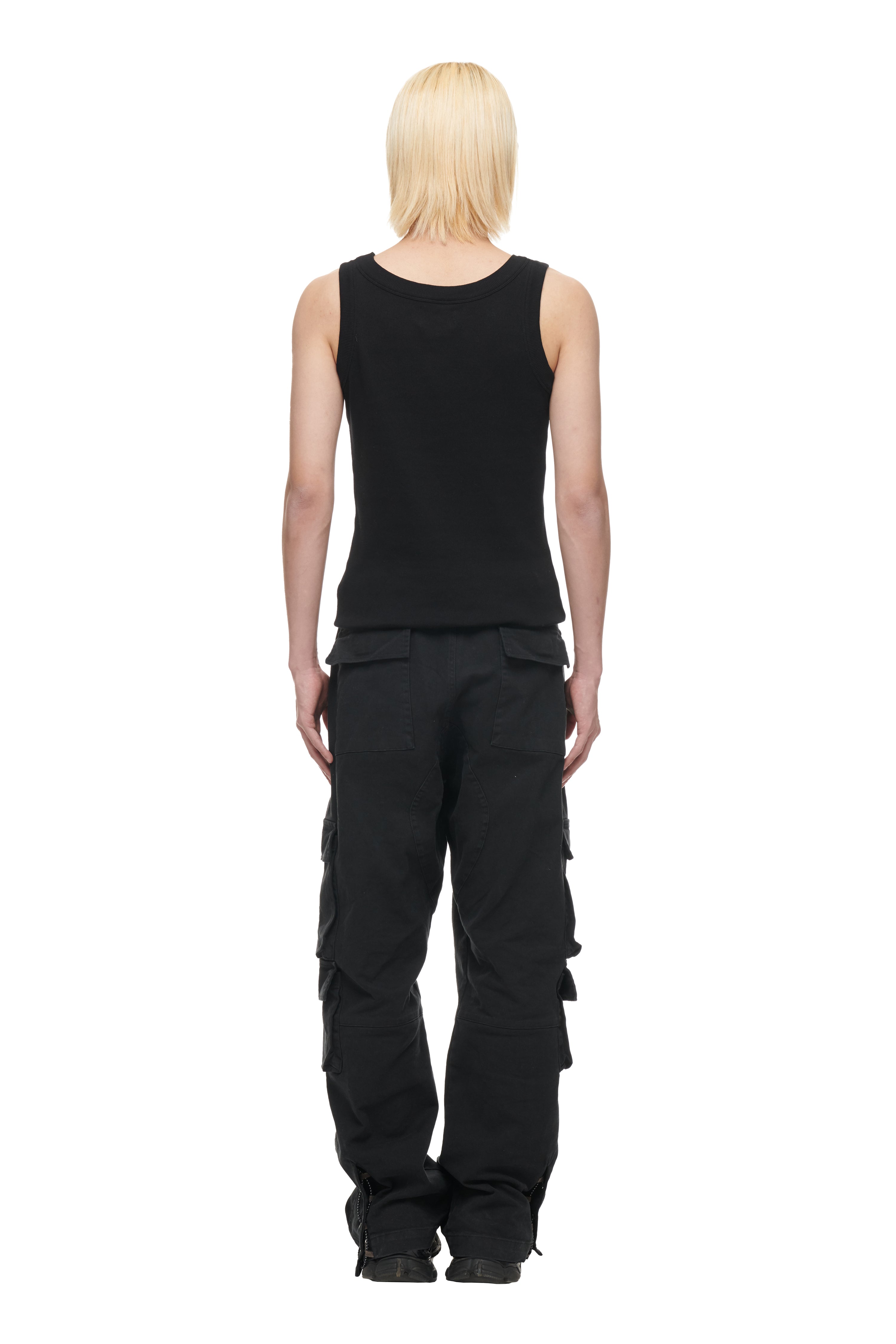 A person with straight, light blond hair stands facing away from the camera against a white background, wearing the 6PM TANK TOP BLACK (2-PACK) and black cargo pants.