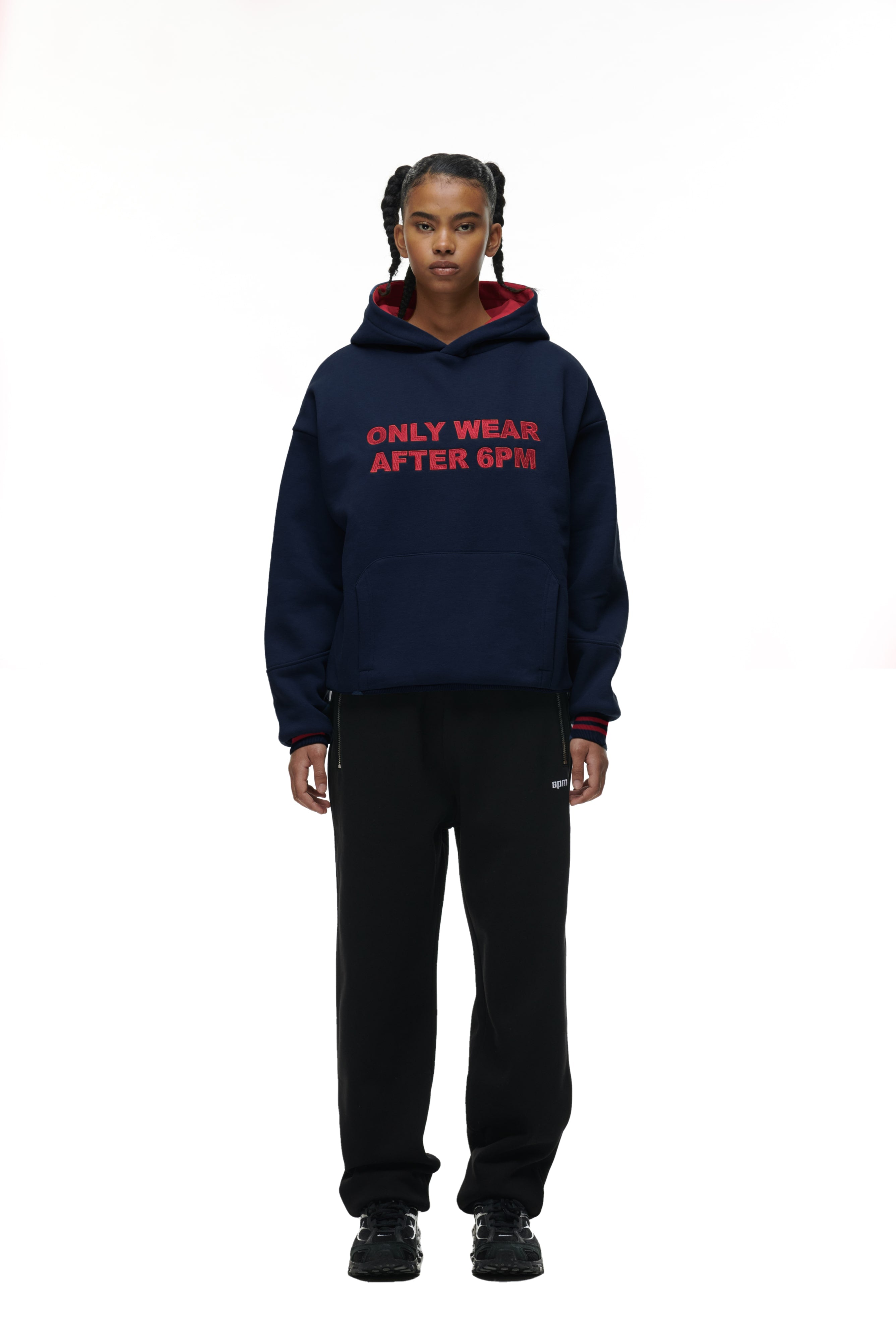 A person faces forward, wearing the 6PM ONLY WEAR HOODIE NAVY with red text, paired with black pants and sneakers against a plain white background.