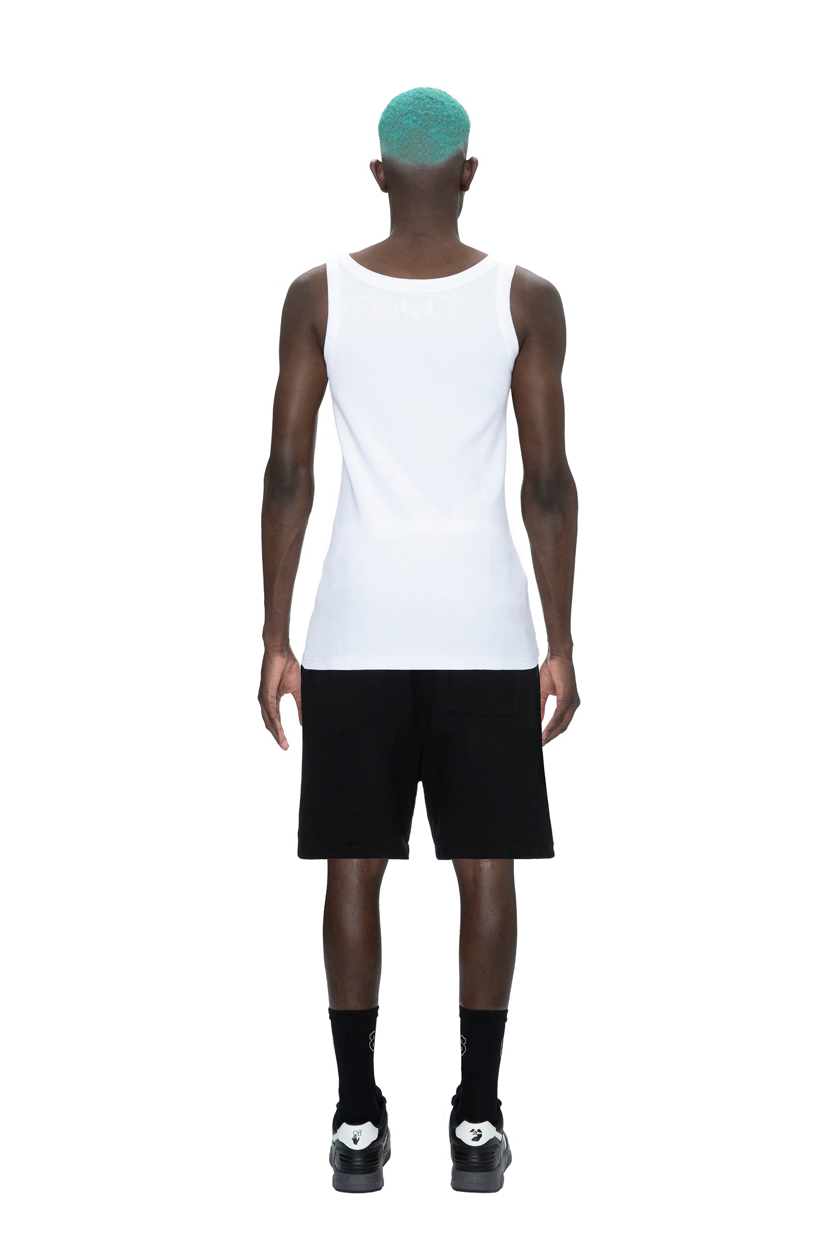 A person with teal hair faces away against a plain white background, wearing a white sleeveless tank, black socks, black shoes, and 6PM SWEATSHORTS BLACK.