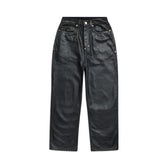 The WAX COATED DENIM BLACK pants by 6PM feature a high waist, five pockets, straight legs, belt loops, and visible stitching in black faux leather, shown laid flat against a white background.