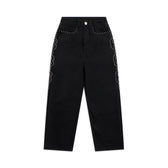 The STUDS DENIM BLACK jeans by 6PM feature a high-waisted wide-leg fit, silver studs on the pockets, and a wavy studded pattern along both outer seams. Finished with a button and zip closure.