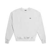 The 6PM CREWNECK COCONUT WHITE is a plain white sweatshirt with long sleeves, ribbed trims, and a small black logo on the left chest, displayed flat on a white background.