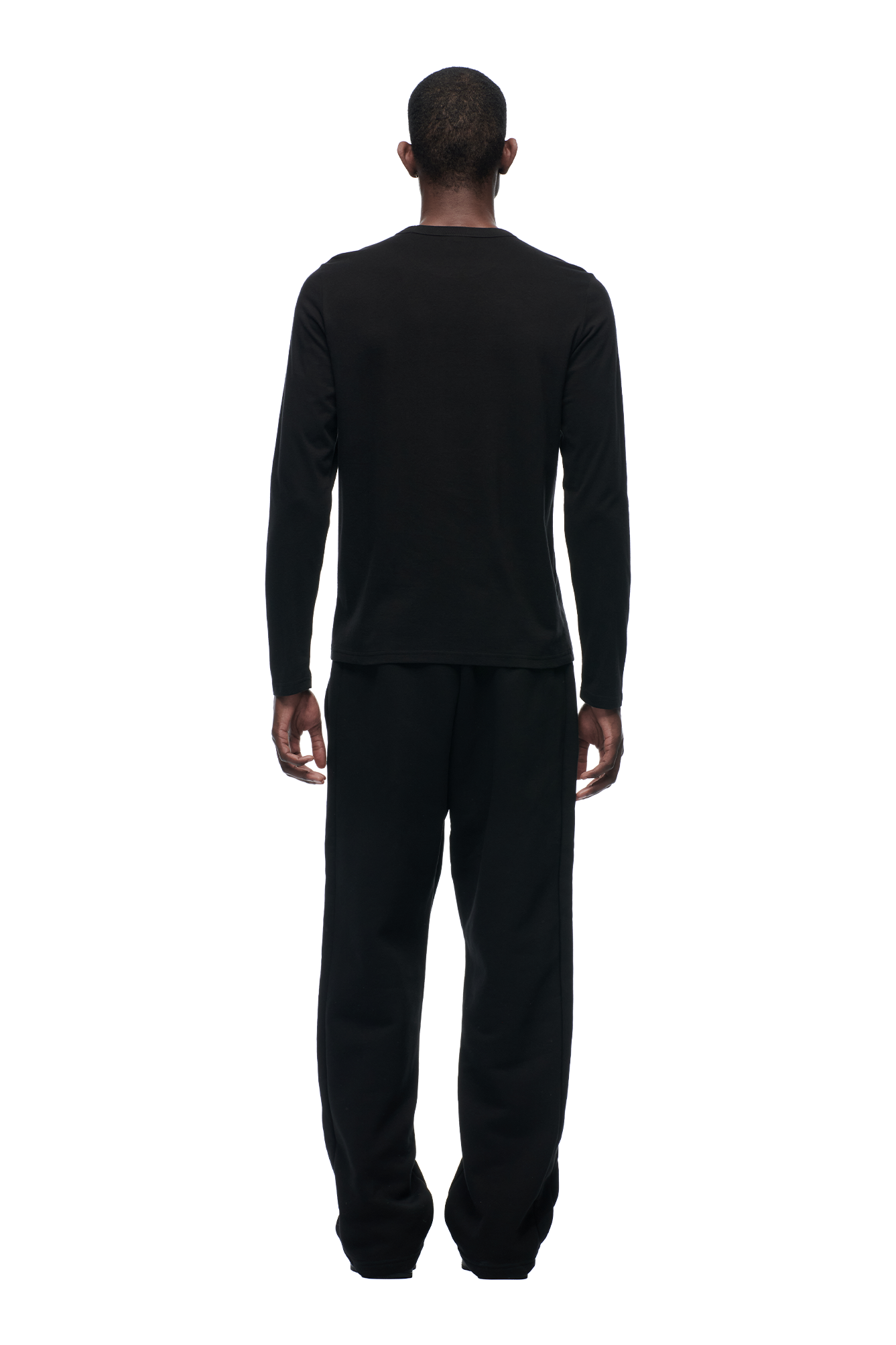 A person faces away from the camera against a white background, wearing the 6PM CLEAN LONGSLEEVE BLACK shirt and black pants.