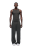 A man faces forward wearing 6PM's OPEN LEG JOGGER DARK GREY MELANGE pants, a fitted dark gray tank top, and white sneakers against a plain white background.