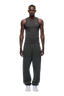 A man faces forward against a plain white background, wearing the 6PM CUFF JOGGER DARK GREY MELANGE sweatpants with a matching dark gray sleeveless tank top and white sneakers.