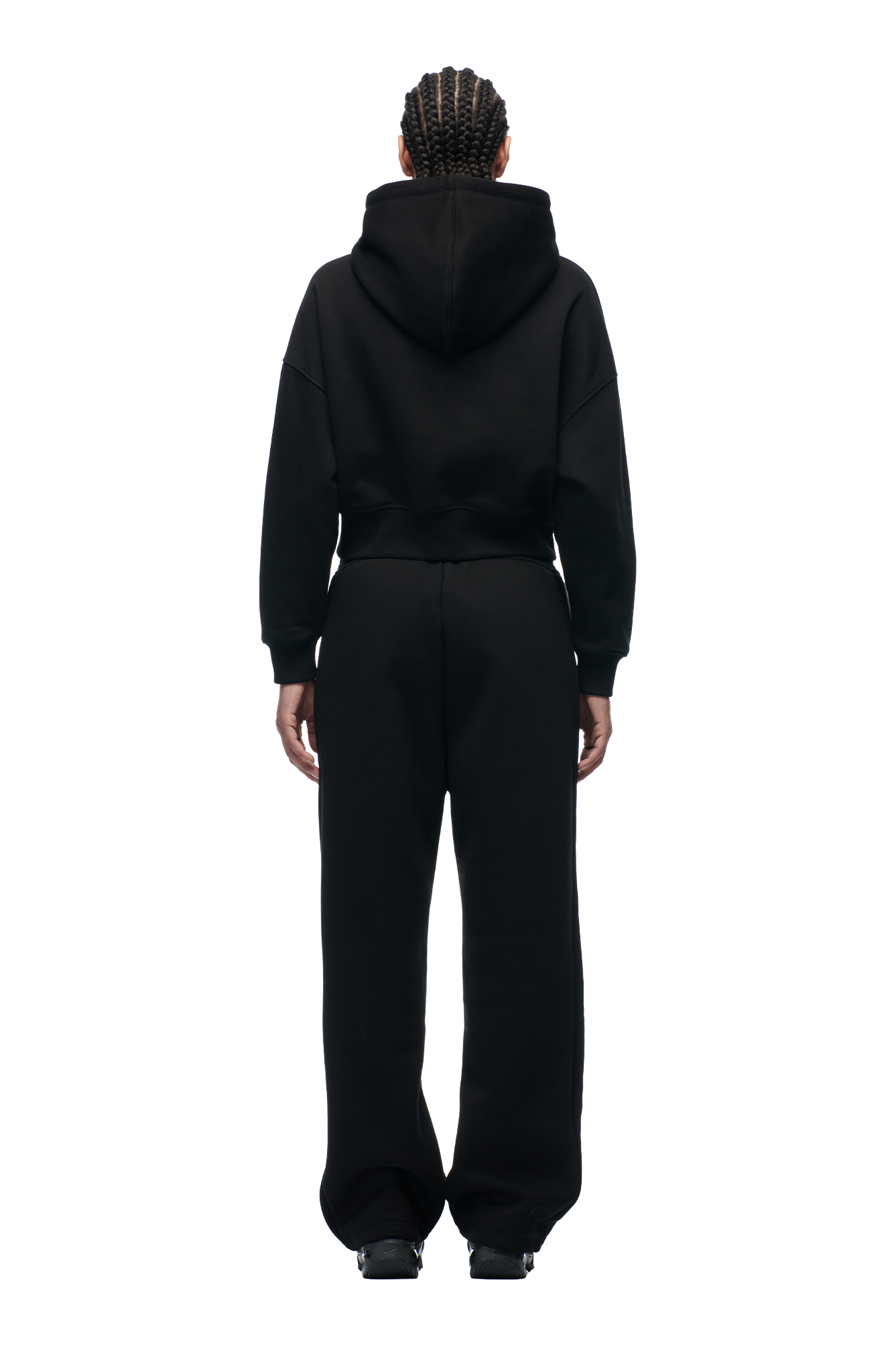 A person with braided hair faces away, wearing the 6PM WMNS CROPPED HOODIE BLACK against a plain white background.