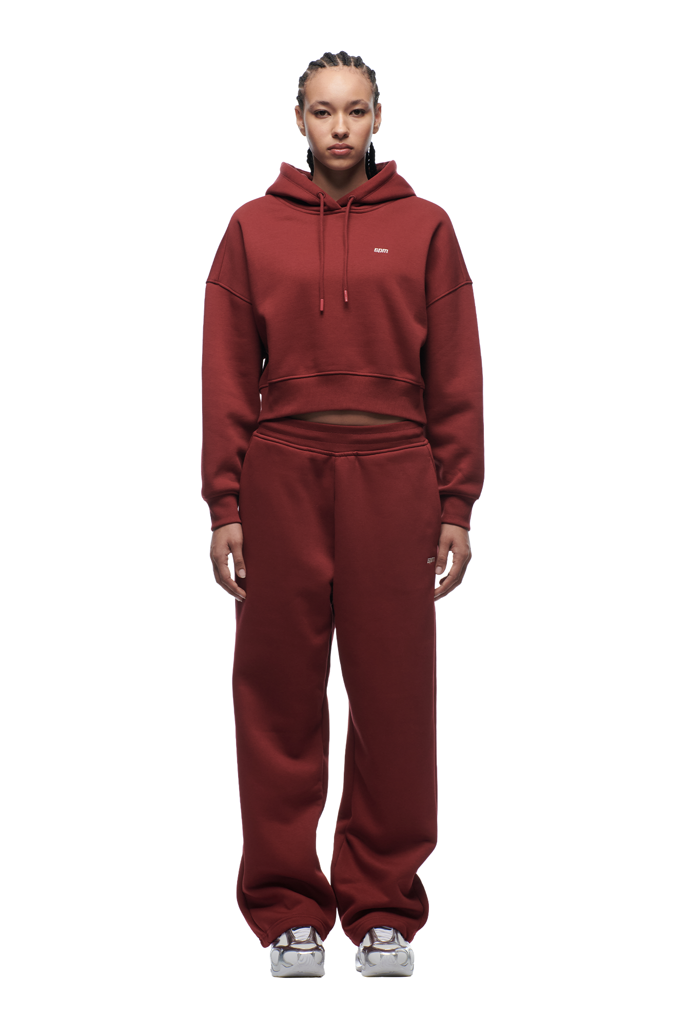 A woman faces forward against a plain white background, wearing the 6PM WMNS CROPPED HOODIE WINE RED with matching sweatpants and white sneakers; the relaxed, comfortable set features a cropped hoodie.