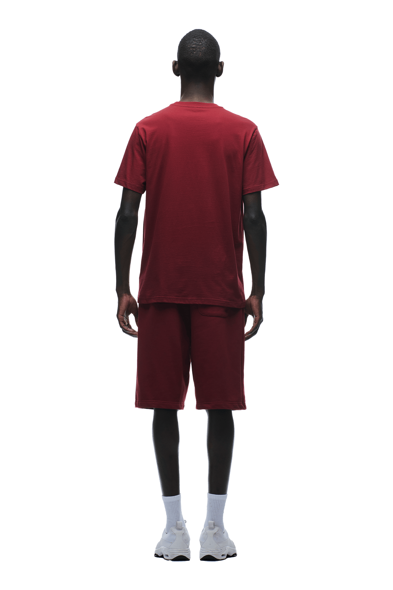 A person faces away, showing off 6PMs T-SHIRT REGULAR FIT WINE RED with matching shorts, white socks, and sneakers against a plain green background.