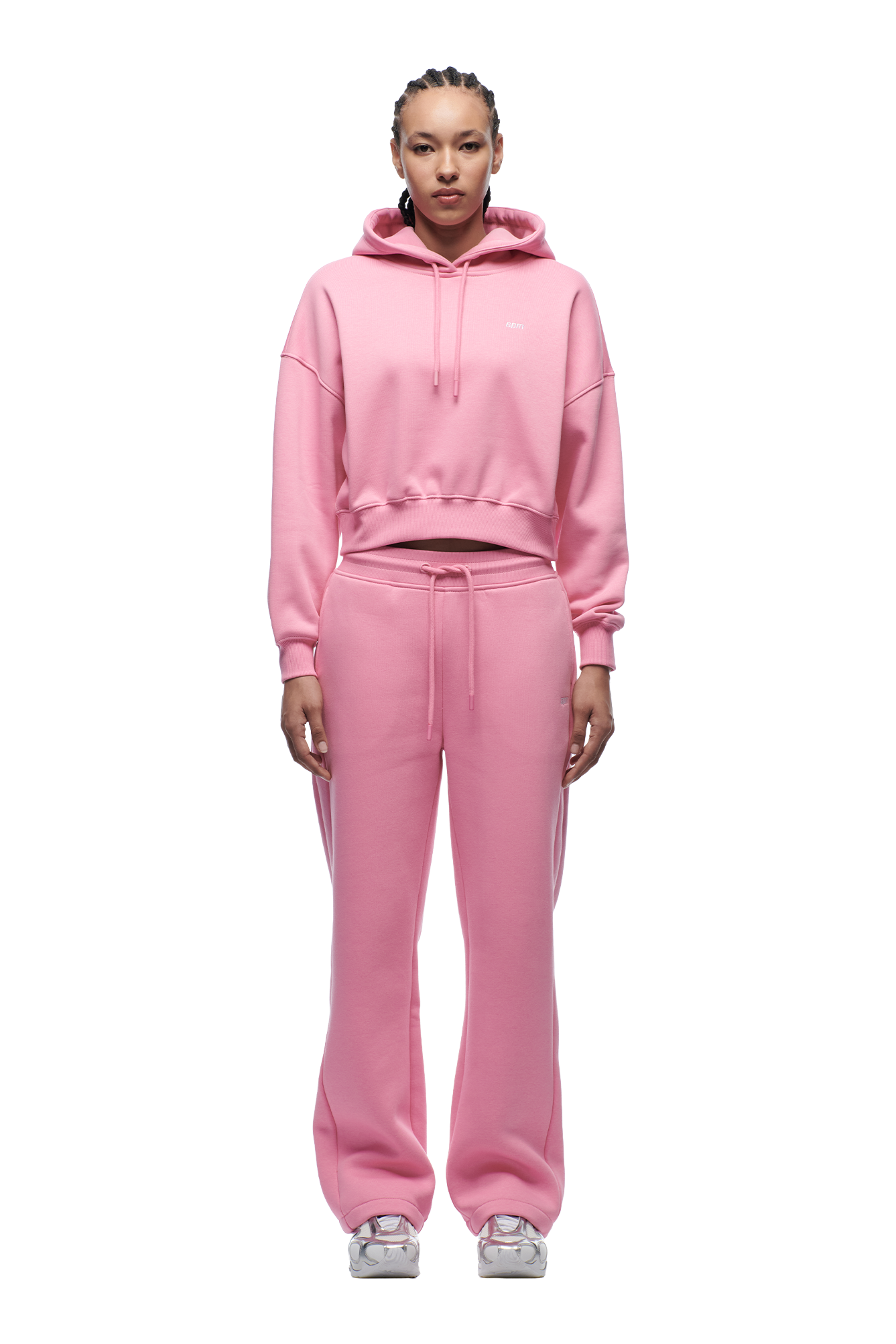 A person faces forward in a 6PM WMNS CROPPED HOODIE BUBBLEGLOW set and white sneakers, against a plain white background.