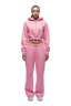 A woman with braided hair faces forward, wearing the 6PM WMNS CROPPED ZIP HOODIE BUBBLEGLOW in light pink, matching sweatpants, and white sneakers against a plain white background.