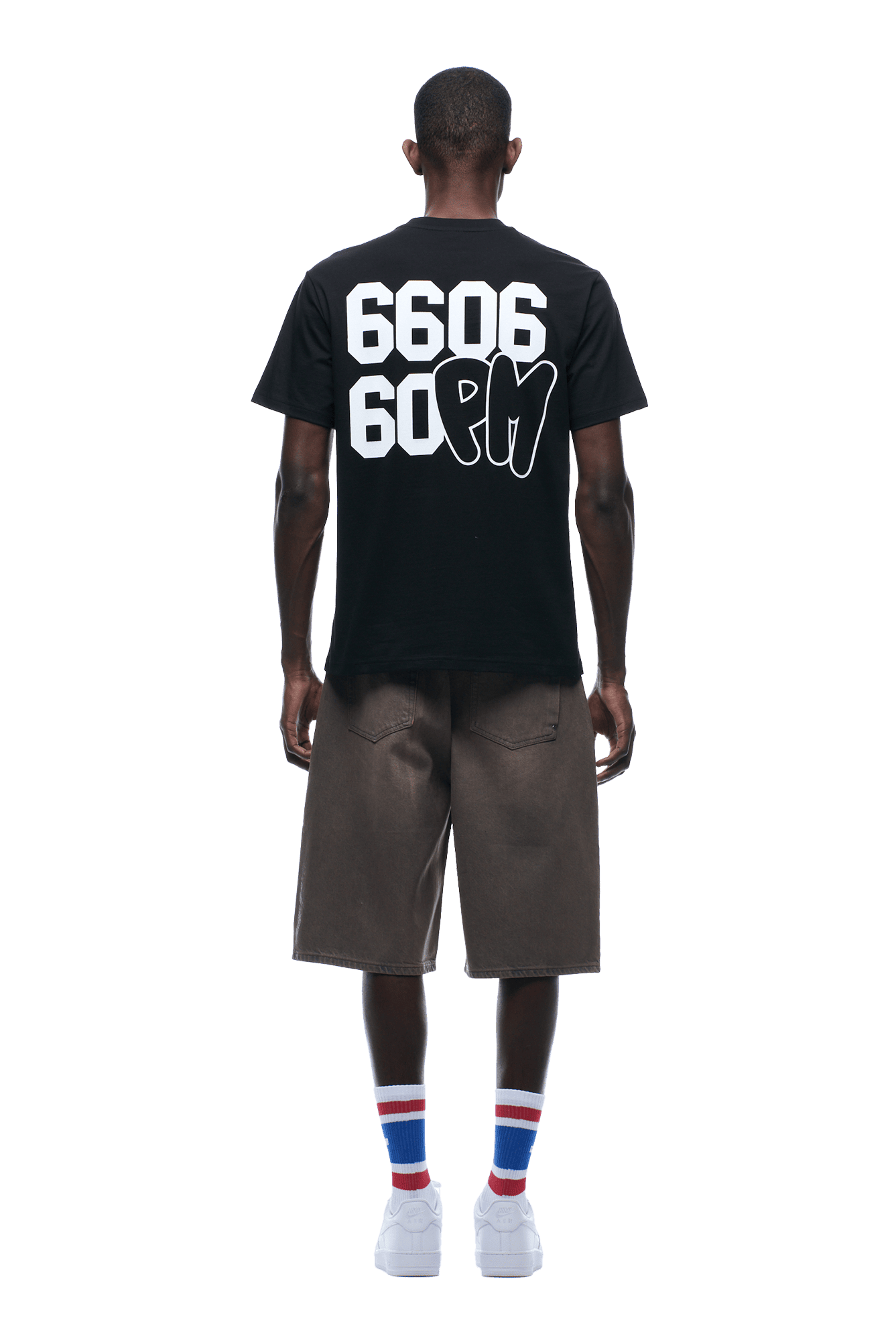 A person faces away wearing the 6PM 660660 TEE BLACK with bold white 6606 60PM text on the back, knee-length brown shorts, white sneakers, and white socks with blue and red stripes. The background is transparent.