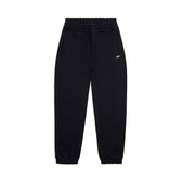 The CUFF JOGGER BLACK features an elastic waistband, cuffed leg openings, two side pockets, and a small white logo on the upper left. These classic black sweatpants are displayed laid flat on a white background.