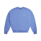 The 6PM CREWNECK PERSIAN BLUE is a light purple crewneck sweatshirt featuring long sleeves, ribbed trims, and a small white logo on the chest, shown laid flat on a white background.