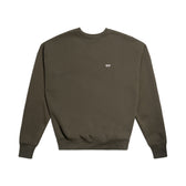 The 6PM CREWNECK FOREST NIGHT is an olive green, boxy-fit crewneck sweatshirt with long sleeves, ribbed cuffs, and a small white embroidered logo on the left chest, shown laid flat on a white background.