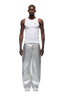 A man faces forward against a white background, wearing a fitted white tank, 6PM’s WAX COATED DENIM SILVER SURFER pants, and white sneakers.