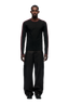 A man faces forward wearing the 6PM GRAFFITI RINGER LS BLACK, a black long-sleeve shirt with maroon stripes and color-block cuffs, paired with loose black pants against a white background.