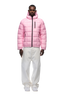 A man faces forward wearing the 6PM LIGHT PUFFER JACKET RECTANGLES PINK with an adjustable hood and black zippers, paired with baggy white pants and white sneakers, set against a plain white background.
