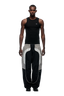 A man stands facing forward against a plain white background, wearing the 6PM EVERYDAY TRACK PANTS BLACK, featuring loose fit, white trim, and zipped pockets, paired with a black sleeveless tank top.