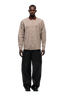 A man faces forward against a white background, wearing the 6PM POLO COLLAR SHIRT COCOA BROWN with horn buttons and a ribbed collar, paired with loose-fitting black pants.