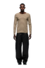 A man faces forward wearing the 6PM STRIPED RIBBED LS DARK HAZELNUT top and loose black pants with black shoes, set against a plain light background.
