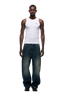 A man faces forward in a fitted white tank top and 6PM's X-TRA WIDE DENIM DARK BLUE jeans, paired with black shoes, set against a plain white background.