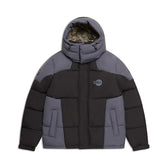 The 6PM COLOUR BLOCKING PUFFER BLACK/ANTHRACITE is a gray and black hooded jacket with a front zipper, patterned hood lining, logo patch on the left chest, color-block design, and insulated sections.