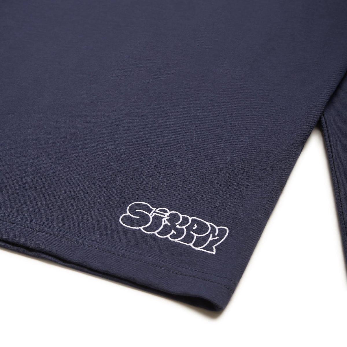 A midnight blue GRAFFITI RINGER LS T-shirt by 6PM featuring "SiXPM" in white bubble letters near the bottom hem.