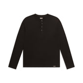 The 6PM BUTTONED SLIM FIT LS BLACK is a slim-fit black long-sleeve Henley shirt with a round neckline and four-button placket, shown on a white background.