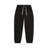 The 6PM X-TRA WIDE CUFF JOGGER BLACK features black sweatpants with an elastic waistband, white drawstring, and elastic ankle cuffs, shown on a white background.