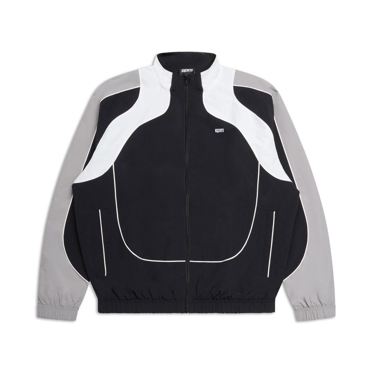 The 6PM EVERYDAY TRACK JACKET BLACK features light grey sleeves, white curved chest and shoulder accents, a high collar, elastic cuffs, zip-up front, and a small white logo on the left chest.