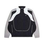 The 6PM EVERYDAY TRACK JACKET BLACK features light grey sleeves, white curved chest and shoulder accents, a high collar, elastic cuffs, zip-up front, and a small white logo on the left chest.