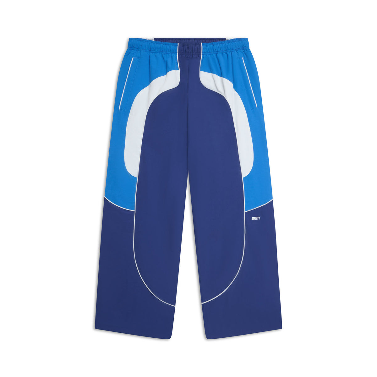 The 6PM EVERYDAY TRACK PANTS SHADOW BLUE feature blue and white wide-leg panels, white piping, an elastic waistband, and side pockets, shown on a white background.