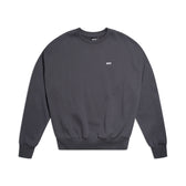 The 6PM CREWNECK ANTHRACITE is a plain, dark gray crewneck sweatshirt with a boxy fit, long sleeves, ribbed trims, and a small white embroidered logo on the chest, shown on a white background.