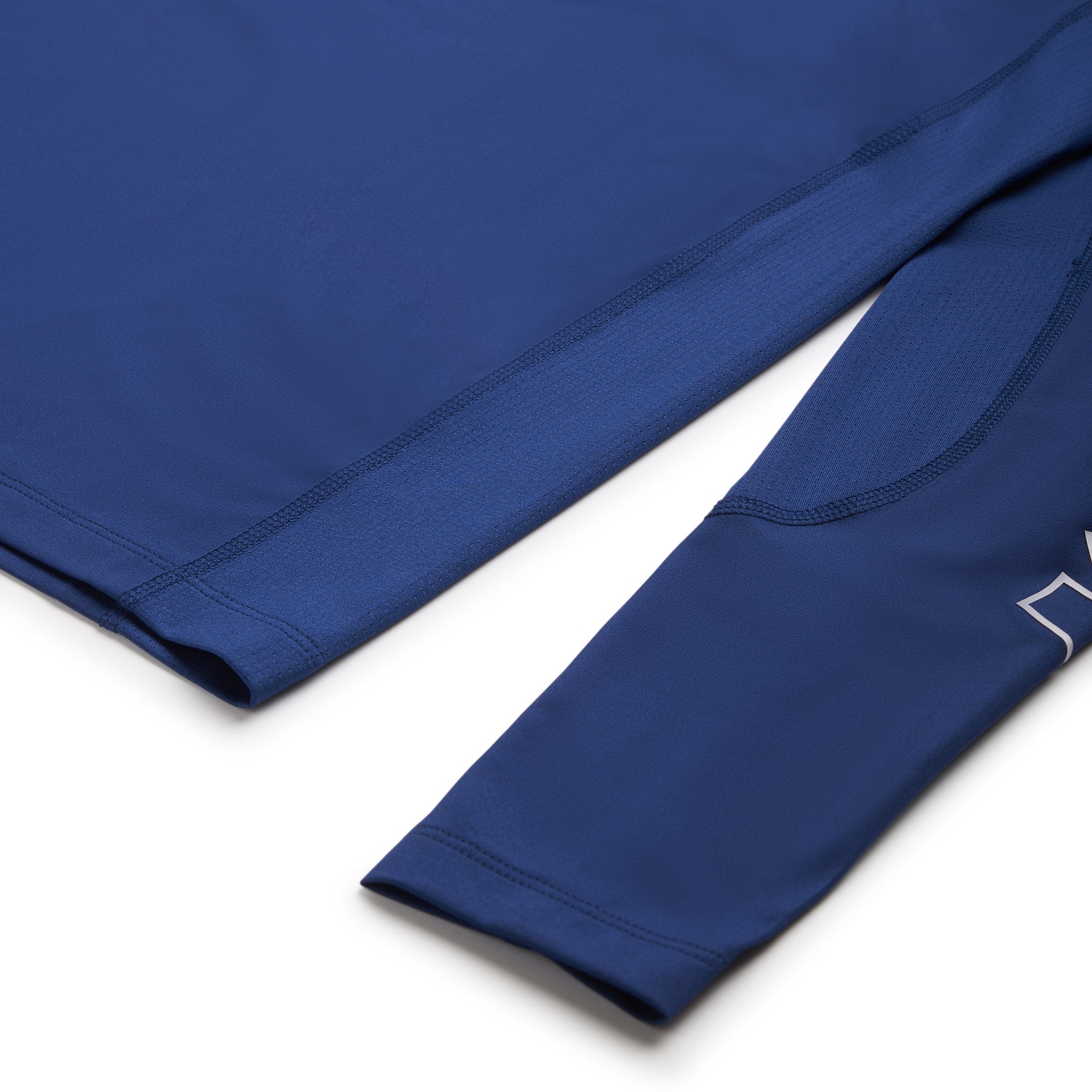 Close-up of the 6PM SPORTS LONGSLEEVE DEEP SEA BLUE shirt by 6PM, laid flat to show the sleeve, body, visible stitching, and mesh-like texture.