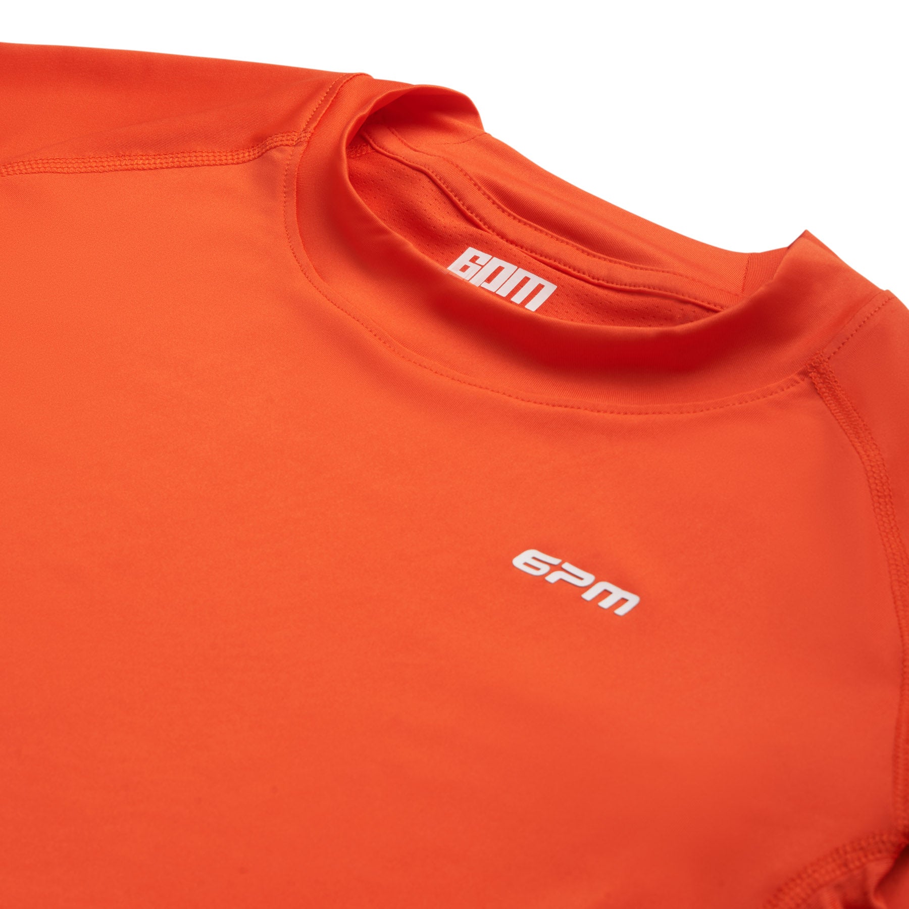 Close-up of the 6PM SPORTS LONGSLEEVE SUNSTONE RED by 6PM, featuring white BOM text on the inner collar, an epm logo on the chest, visible stitching, and a smooth, stretchy athletic fabric.