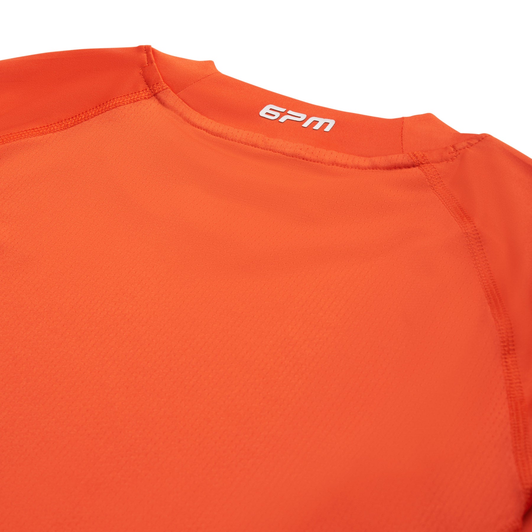 Close-up of the back neckline of the 6PM SPORTS LONGSLEEVE SUNSTONE RED by 6PM, showing visible stitching and "6PM" printed in white near the collar.