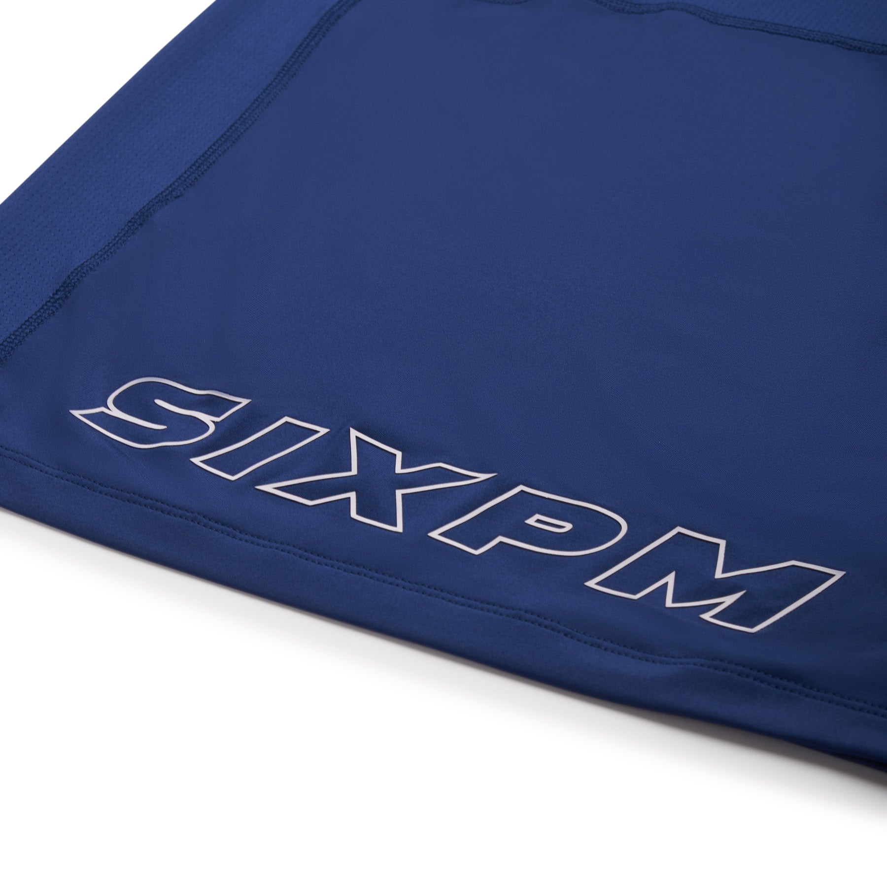 A close-up of the 6PM SPORTS T-SHIRT DEEP SEA BLUE by 6PM, featuring large, outlined white "SIXPM" block letters near the edge.