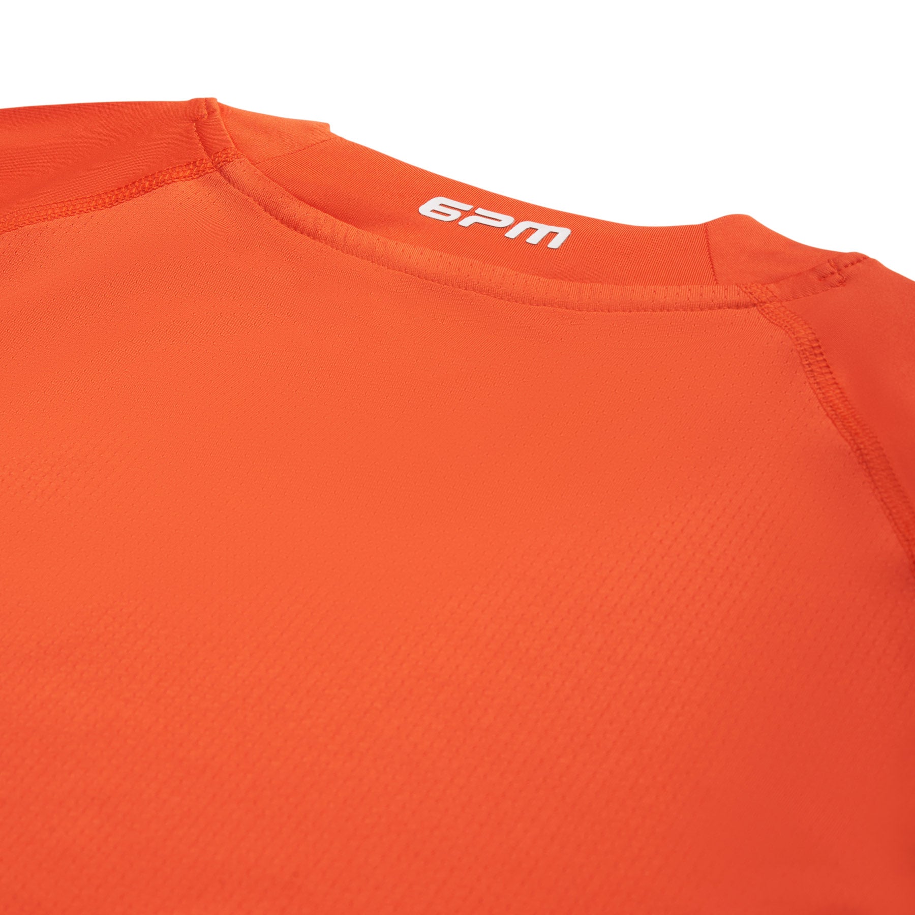 Close-up of the back neckline of the 6PM SPORTS T-SHIRT SUNSTONE RED by 6PM, showing visible stitching and "6PM" printed in white inside the collar.