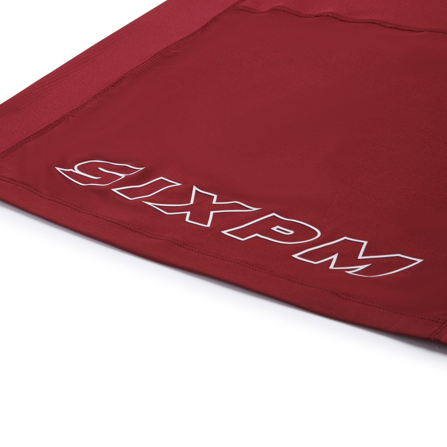 A close-up of the 6PM SPORTS T-SHIRT WINE RED by 6PM shows the brand name printed in bold, white, outlined letters on the edge of the red fabric.