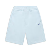 The 6PM+ SHORTS ICE BLUE feature a relaxed fit, elastic waistband, two side pockets, and a small blue 8PM logo on the left thigh. These light blue athletic shorts have a soft interior and are shown laid flat against a white background.